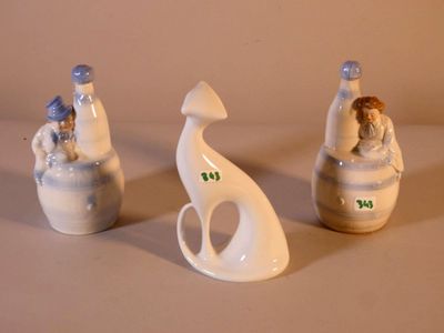 trois figurines assises l'une à côté de l'autre
