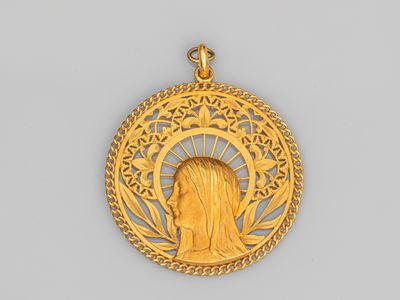 un gros plan sur une médaille d'or avec le visage d'une femme au centre