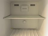a small white refrigerator with its door open in a kitchen
