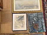 il y a beaucoup d'œuvres d'art encadrées par terre dans cette pièce