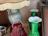 a table with a lamp, vases, and other items on it