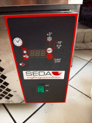 une machine rouge et noire posée sur un sol carrelé