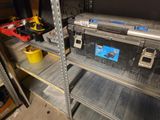 une étagère métallique sur laquelle sont posés des outils, dans un garage