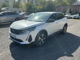 un SUV blanc garé sur un parking à côté d'un immeuble