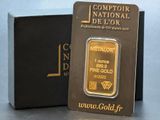 un lingot d'or posé devant une boîte noire