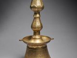 an old brass candle holder with a bird on top