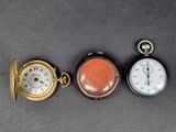 three different types of pocket watches on a table