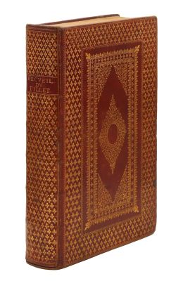 un vieux livre à la couverture brune posé sur une surface blanche