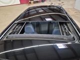 a black car with its hood open in a garage