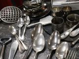 a lot of silver spoons and silverware on the table