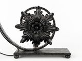 a metal sculpture of a flower on a stand