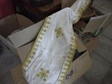 une couverture blanche et jaune dans une boîte posée par terre
