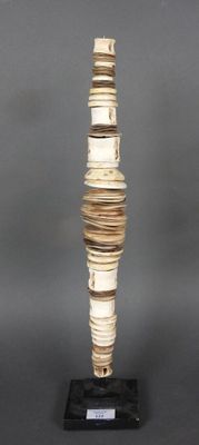 un grand vase fait de livres, posé sur un socle noir