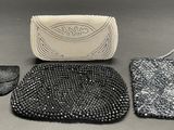three purses and a handbag sitting on top of a table