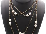 a close up of a necklace on a mannequin with pearls