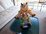 une statue représentant un clown posée sur une table dans un salon