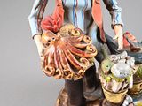 a figurine of a man holding a basket of fish