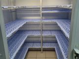 an empty refrigerator with shelves in the middle of it