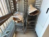many trays of doughnuts on the shelves in the kitchen