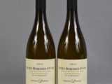 two bottles of wine sitting on top of a table next to each other