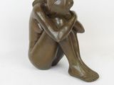 statue of a woman sitting on her knees with her hands on her knees