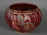 a red vase with a dragon on it sitting on a table
