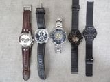 several different watches are lined up on a table