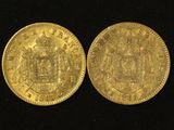 a close up of two gold coins on a black surface