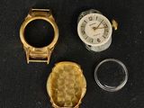 trois montres et une bague posées sur une surface noire