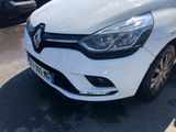 the front end of a white car parked in a parking lot