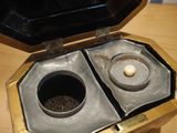 a metal container with two cups inside of it on a wooden table