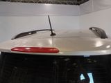 a white car with a red tail light in a garage