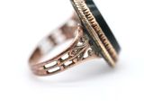 a close up of a ring with a black stone in it
