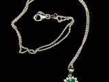 a necklace with a green stone and a silver chain
