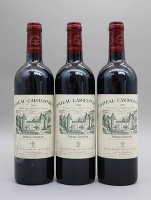 trois bouteilles de vin rouge posées côte à côte sur une table