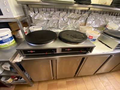 stainless steel counter top with pots and pans on it in a commercial kitchen