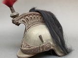 an old helmet with a red feather on top of it