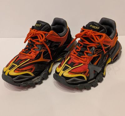 une paire de chaussures de course noires et orange avec des lacets orange
