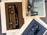 several photographs of old cars are displayed on a table