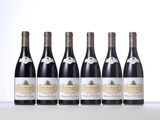 six bottles of wine are lined up on a table