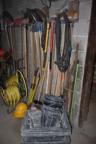 Lot d’outillage à mains : pelles, balais. Deux tuyaux d’arrosage ...