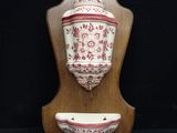 a wall mounted vase and a bowl on a wooden stand