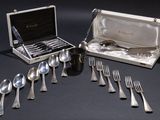 silverware in a silver case on a black table