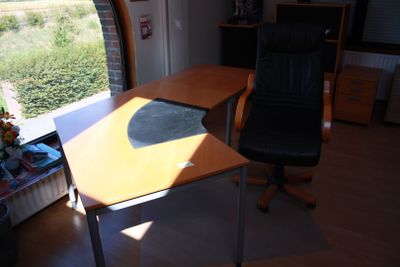 a desk with a chair in front of a window
