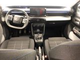 the interior of a small car with a steering wheel and dashboard