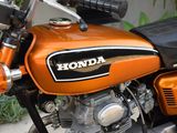 an orange motorcycle parked on the side of the street