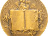 an image of a gold medal with an open book on it