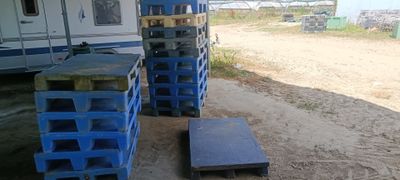 de nombreuses caisses bleues empilées au bord de la route