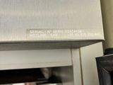 a stainless steel oven with a door open and a person standing in the background