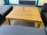a wooden table with a vase on it in the middle of a living room